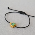 Détail du pendentif lotus en laiton émaillé sur un bracelet en cordon noir tressé - Style Lotus Doré (2)