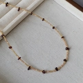 Dettaglio macro della collana in pietre naturali con ametista e sfere dorate - Collana Champagne + Granato Rosso