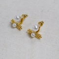 Detail view of brass gold-plated wing earrings featuring two elegant white pearls - Gold Pearl Wing Studs (5)