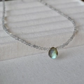 Minimalist labradorite beaded necklace with a teardrop pendant on light fabric padding - Grade B Labradorite