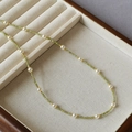 Detalle de collar de circonitas verdes con perlas blancas y separadores dorados - Verde