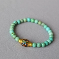 Detailed macro view of turquoise bead bracelet with intricate cloisonne enamel floral bead - Gold Rim Cloisonne Floral Bead Style (18)