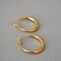 Detail of high-polish gold teardrop hoop earrings on a textured grey fabric background - 3cm / Gold