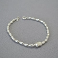 Macro shot of polished silver beaded bracelet with an irregular geometric centerpiece - Silver Bracelet
