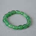 Macro shot of irregular translucent green stone beads on elastic strand for bracelet - Green