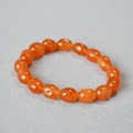 Detail of translucent orange gemstone beads with natural textures on a minimalist bracelet - Orange Red