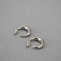 Macro shot of minimalist crescent-shaped silver studs with a polished mirror finish - Platinum Plated