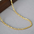 Vista macro della collana a catena dorata con grani ovali lucidi e finiture di alta qualità - Stile 1 Oro