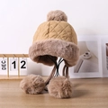 Macro shot of quilted winter hat texture featuring fluffy faux fur trim and soft pom-poms - One Size 58cm / Khaki