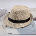 Détail d'un chapeau de paille tissé avec ruban noir posé sur un magazine tendance - Taille Unique 58cm / Grille Mahjong Beige