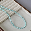 Dettaglio ravvicinato di perline di turchese sfaccettate e distanziatori argentati su velluto - Collana