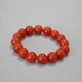 Close-up of 14mm deep red agate beads bracelet featuring glossy finish on grey fabric - 12mm Red Agate