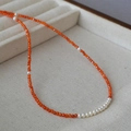 Detail of red agate beaded necklace with white pearls on a soft jewelry display tray - Orange Red