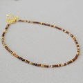 Macro view of French retro agate beaded necklace with golden gear spacers and lobster clasp - Necklace