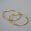 Nahaufnahme von minimalistischen goldenen C-Hoop-Ohrringen auf grauem Stoffhintergrund - Gold 6cm