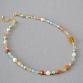 Dettaglio della collana di perle barocche con acquamarina e citrina su sfondo grigio - Stile Collana a Perline