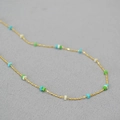 Close-up of gold-plated thin chain necklace with turquoise and white square stone beads - Blue White and Green