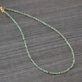 Detail einer handgefertigten Boho-Perlenkette mit türkisfarbenen Perlen und Goldverschluss - Halskette