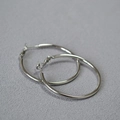 Polished silver C-shaped oversized hoop earrings displayed on grey textured fabric - Platinum 3cm