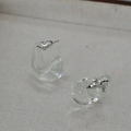 Close-up of minimalist clear glass C-shaped drop earrings with silver butterfly backings - Water Drop