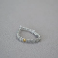 Close-up of handmade woven beaded ring featuring grey gemstones and a gold bead accent - Labradorite Ring