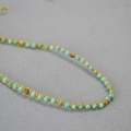 Macro shot of handmade turquoise beads woven with gold thread in bohemian style - Magnesite Necklace