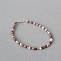 Dettaglio della collana bohémien di perline rosse e viola con chiusura a moschettone in metallo - Bracciale