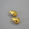 Macro-opname van gouden druppeloorbellen met gefacetteerde textuur en metallic afwerking - Vergulden