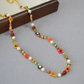 Dettaglio collana boho con perline di vetro colorate e fiori fatti a mano artigianali - Collana