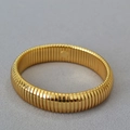 Macro detail of golden Tubogas wide elastic bracelet with polished spiral texture design - Thin Version (Tubogas Style) / Gold
