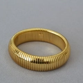 Detailed close-up of wide gold-plated ribbed metal cuff bracelet with high-gloss finish - Wide Version (Tubogas Style) / Gold
