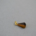 Detalle macro de un colgante cónico de ojo de tigre con conector bañado en oro - Solo colgante