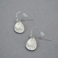 Detail view of water drop earrings with unique hammered texture in silver finish - Silver