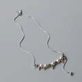 Dettaglio della collana a catena serpente argento con perle bianche e elementi in metallo - Oro bianco