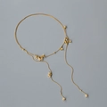 Dettaglio della collana a doppio strato dorata con delicati ciondoli a fiore di cristallo - Oro