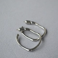 Close-up of silver irregular liquid metal hoop earrings with high polish finish - Small / White Gold