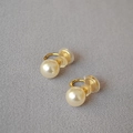 Dettaglio di orecchini a clip con perle, finitura dorata e cuscinetti in silicone - 10mm / Bianco Sporco