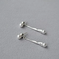 Orecchini a goccia lunghi in argento con perle eleganti su superficie grigia ruvida - Perla artificiale