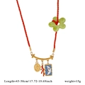Dettaglio della collana in corda rossa con fiore in resina, ciondoli d'oro e luna - Corda Intrecciata Rossa / Madonna Luna Rosso(B)