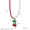 Dettaglio della collana con perle sfaccettate rosse, perle bianche e ciondolo a ciliegia - Stile Ciliegia (C)