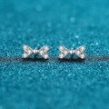 Sparkling S925 silver bow stud earrings with white cubic zirconia on teal background - 0.3 Carat Moissanite / 925 Silver