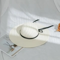 Detailed texture of woven straw sun hat featuring a slim black ribbon and long streamers - M (56-58cm) / Milk White