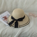 Elegant beige straw beach hat with a large black bow, styled with a magazine and glasses - Kids / Beige