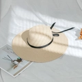 Close-up of the finely woven straw texture and elegant black bow on the sun hat - M (56-58cm) / Beige