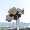 Dettaglio della trama del cappello di paglia con fiocco nero e bordo ondulato decorativo - M (56-58cm) / Cachi