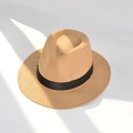 Detail of light camel straw fedora with black ribbon under striped sunlight shadows - L (58-60cm) / Khaki