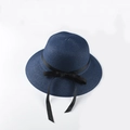 Detailed view of dark blue woven straw texture with a stylish black ribbon bow decoration - Navy Blue