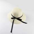 Detail of white straw sun hat featuring a classic black ribbon bow and textured weave - M (56-58cm) / Milk White