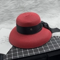 Detail of red straw sun hat with black ribbon bow and gold metal M logo charm - M / Burgundy