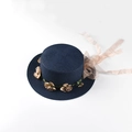 Detail of navy straw hat featuring intricate weave and beige floral wreath with chiffon ribbon - M (56-58cm) / Navy Blue